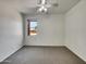 Bright bedroom with neutral carpet, white walls, ceiling fan, and a window view at 43530 W Eddie Way, Maricopa, AZ 85138