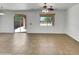Bright living room featuring neutral walls, tile flooring, and sliding glass door to outdoor space at 43530 W Eddie Way, Maricopa, AZ 85138