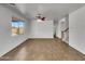 Bright living room features tile flooring, a ceiling fan, and view of staircase at 43530 W Eddie Way, Maricopa, AZ 85138