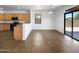 A well-lit living room with tile flooring, view of the backyard and convenient kitchen access at 43530 W Eddie Way, Maricopa, AZ 85138