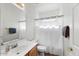 Clean bathroom with a single sink vanity, shower, and bathtub combination with white tile surround at 462 W Myrtle Dr, Chandler, AZ 85248