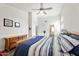 Bright bedroom features a ceiling fan, wood dresser, and a comfortable-looking bed with blue accents at 462 W Myrtle Dr, Chandler, AZ 85248