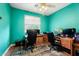 Bedroom with teal walls, wood-look floors, a ceiling fan, and built-in desk and shelving at 462 W Myrtle Dr, Chandler, AZ 85248