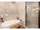 Bathroom featuring a soaking tub with tile surround, a shower with glass door, and a wooden stool at 5350 E Deer Valley Dr # 3274, Phoenix, AZ 85054