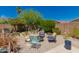 Backyard with gravel and a fire pit surrounded by outdoor seating and lush landscaping at 6031 N Milano Ct, Litchfield Park, AZ 85340