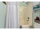 Bathroom showcasing a shower-tub combo with white shower curtain and wall shelving at 6031 N Milano Ct, Litchfield Park, AZ 85340