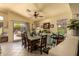 Bright dining area featuring a large wooden table, ceiling fan and sliding glass doors at 6031 N Milano Ct, Litchfield Park, AZ 85340