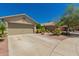 Well maintained single story house with tan exterior, two-car garage and desert landscaping at 6031 N Milano Ct, Litchfield Park, AZ 85340
