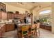 Bright eat-in kitchen with wood cabinets, stainless appliances, a brick-accented island, and window seating at 6031 N Milano Ct, Litchfield Park, AZ 85340