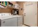 Functional laundry room with washer, dryer, and storage shelves at 6031 N Milano Ct, Litchfield Park, AZ 85340