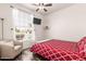 Comfortable bedroom with a ceiling fan, plush chair, and a large window overlooking the neighborhood at 6156 W Del Rio St, Chandler, AZ 85226