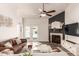 Cozy living room with a fireplace, ceiling fan, and a view of the backyard pool through french doors at 6156 W Del Rio St, Chandler, AZ 85226
