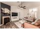 Open living space with a fireplace, ceiling fan, and a large TV; blending comfort and functionality at 6156 W Del Rio St, Chandler, AZ 85226