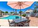Outdoor dining beside sparkling pool with shade umbrella, lounge chairs, and easy access to relax in style at 6156 W Del Rio St, Chandler, AZ 85226