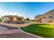 Backyard with an outdoor kitchen, putting green, and hardscaped walkway. Plenty of room to entertain at 6286 S Reseda St, Gilbert, AZ 85298