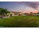A spacious backyard with a pristine lawn leads to an outdoor kitchen and well-appointed home at 6286 S Reseda St, Gilbert, AZ 85298