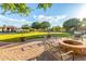 Spacious backyard with a brick patio, fire pit, lush lawn, and inviting pool at 6286 S Reseda St, Gilbert, AZ 85298