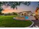 Expansive backyard with lush lawn, swimming pool, and outdoor kitchen, perfect for entertaining at 6286 S Reseda St, Gilbert, AZ 85298