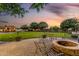 Beautiful backyard features a fire pit, lush lawn, swimming pool, and outdoor kitchen for entertaining at 6286 S Reseda St, Gilbert, AZ 85298
