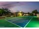 Night view of the private backyard basketball court with lighting and tennis net at 6286 S Reseda St, Gilbert, AZ 85298