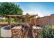 Outdoor garden featuring a charming wooden pergola, stone pillars, and lush greenery at 6286 S Reseda St, Gilbert, AZ 85298