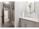 Bathroom featuring a white vanity with a round mirror and a shower-tub combination at 634 W Aviary Way, Gilbert, AZ 85233