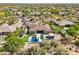 An aerial view shows a home with a pool, putting green, and outdoor kitchen in a desert landscape at 7032 E Balancing Rock Rd, Scottsdale, AZ 85266