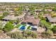 Aerial view showcases a home with a pool, putting green, and desert landscaping in a residential area at 7032 E Balancing Rock Rd, Scottsdale, AZ 85266