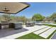 Outdoor kitchen, dining area, pool, and manicured grass create a backyard perfect for entertaining at 7032 E Balancing Rock Rd, Scottsdale, AZ 85266