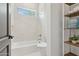 Bright bathroom featuring white tile, a large tub, a window, and shelving at 7032 E Balancing Rock Rd, Scottsdale, AZ 85266