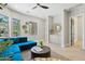 Bright living room with a modern teal sectional sofa, hardwood floors, and large windows at 7032 E Balancing Rock Rd, Scottsdale, AZ 85266