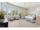Bright main bedroom features large windows, seating area, and a modern ceiling fan at 7032 E Balancing Rock Rd, Scottsdale, AZ 85266