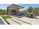 Outdoor kitchen with grill, bar seating, ceiling fan, tv, and dining table on a paved patio at 7032 E Balancing Rock Rd, Scottsdale, AZ 85266