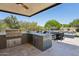 Outdoor kitchen with a stainless steel grill and a view of the pool area at 7032 E Balancing Rock Rd, Scottsdale, AZ 85266