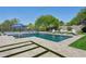 Backyard pool area with tiled pool, waterfall feature, poolside seating, and landscaping at 7032 E Balancing Rock Rd, Scottsdale, AZ 85266
