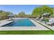 Backyard pool with a waterfall feature, poolside seating, and beautiful desert landscaping at 7032 E Balancing Rock Rd, Scottsdale, AZ 85266