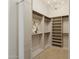 Bright walk-in closet with custom shelving, drawers, and decorative chandelier lighting at 7032 E Balancing Rock Rd, Scottsdale, AZ 85266