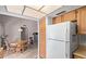 Bright kitchen with white refrigerator, wood cabinets and adjacent dining area at 7333 N 69Th Ave, Glendale, AZ 85303