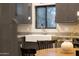Modern kitchen featuring gray cabinets, granite countertops, a farmhouse sink, and stainless steel appliances at 7857 N 21St Ave, Phoenix, AZ 85021