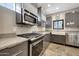 Contemporary kitchen featuring granite countertops, stainless steel appliances, and gray cabinetry at 7857 N 21St Ave, Phoenix, AZ 85021