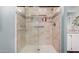 Tiled shower featuring a glass door, convenient grab bars, and practical storage shelves at 8209 E 5Th Ave, Mesa, AZ 85208