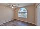 Comfortable bedroom featuring wood floors, a ceiling fan, and a large window for natural light at 825 E Michigan Ave, Phoenix, AZ 85022