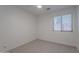 Bright bedroom offers a blank canvas with neutral carpet, ceiling fan, and a large window at 830 S Cerise --, Mesa, AZ 85208