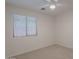 Well-lit bedroom with neutral carpet, window, and ceiling fan at 830 S Cerise --, Mesa, AZ 85208