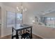 A cozy breakfast table is illuminated by a modern chandelier near a large window and open living space at 830 S Cerise --, Mesa, AZ 85208