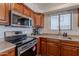 Kitchen showcasing stainless steel microwave, range, sink and wood cabinetry at 830 S Cerise --, Mesa, AZ 85208
