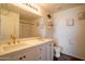 Bathroom featuring double sinks, white cabinets, gold fixtures, and a large mirror above the vanity at 8516 N 64Th Ave, Glendale, AZ 85302