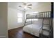 Bedroom with wood floors featuring a bunk bed and a ceiling fan at 8516 N 64Th Ave, Glendale, AZ 85302