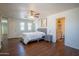 Spacious main bedroom featuring wood floors, a ceiling fan, ensuite bathroom, and lots of natural light at 8516 N 64Th Ave, Glendale, AZ 85302