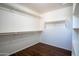 Large walk-in closet with wood floor, white walls, and built-in shelving at 8516 N 64Th Ave, Glendale, AZ 85302